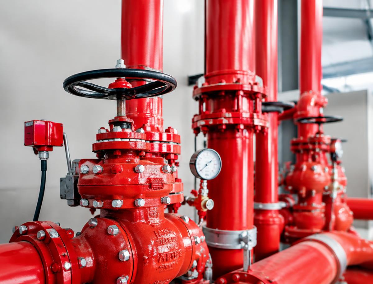 Red fire sprinkler valves and pipework in a plant room